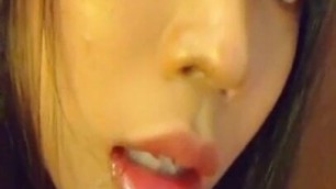 Young Asian squirts on her face and into her mouth.
